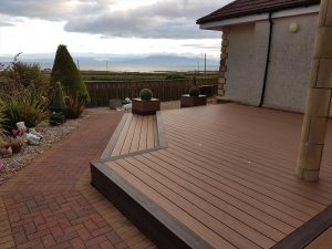 Brown Trex decking area with planters next to house