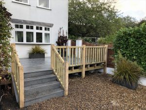 Raised grey Trex deck with steps down to garden