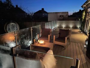 Trex deck with glass railings and lighting at night