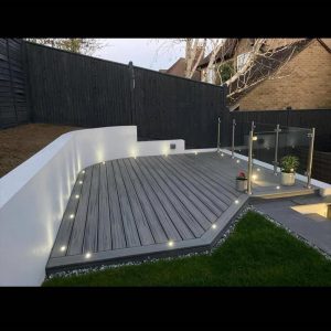 Grey Trex deck with integrated spotlight and clear glass railings