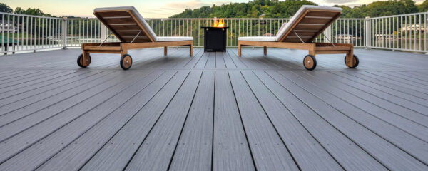 Beautiful composite decking with white railing looking out onto a lake.